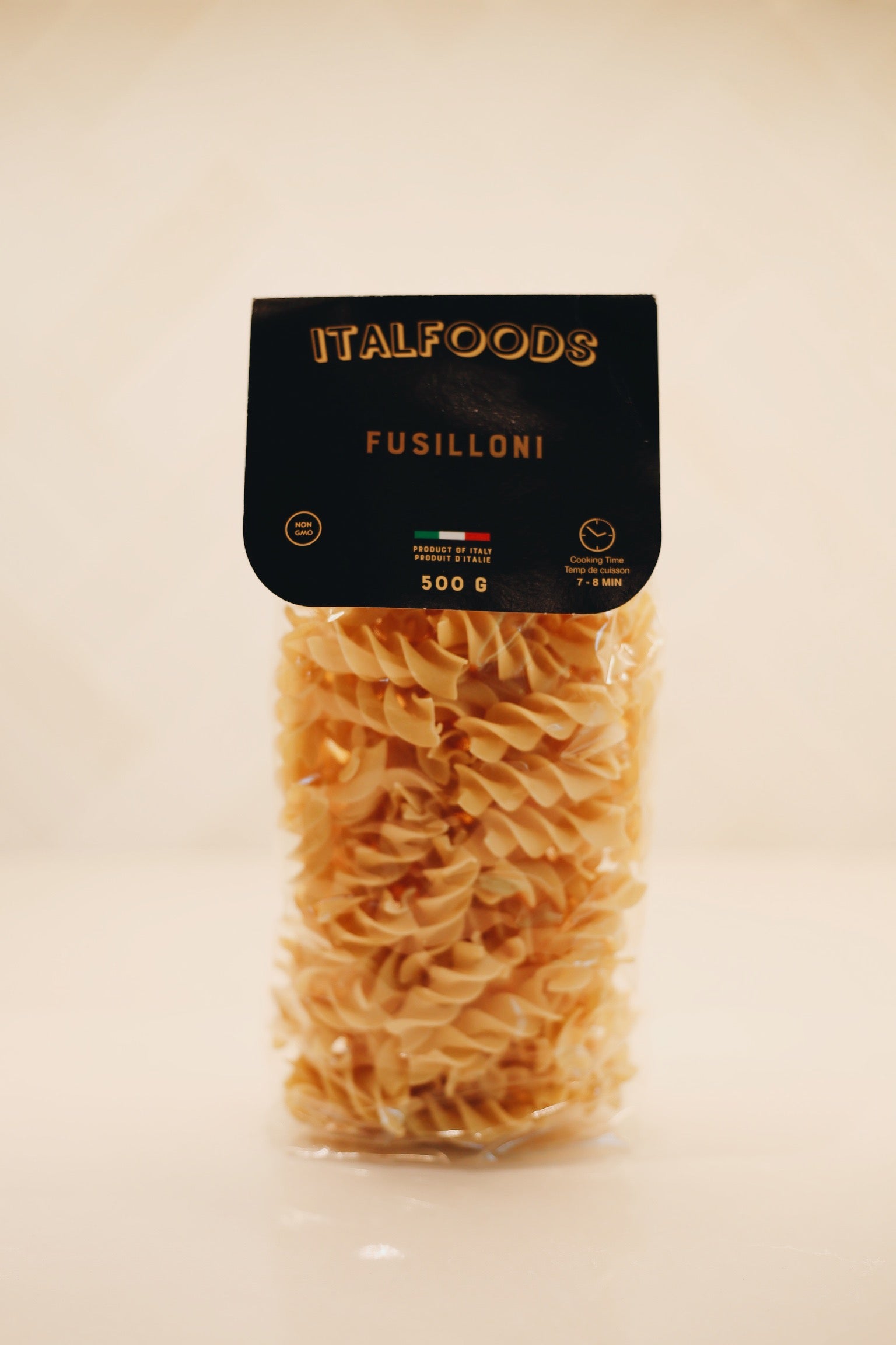 Packaged fusilli pasta with 'Italfoods' branding on a beige background