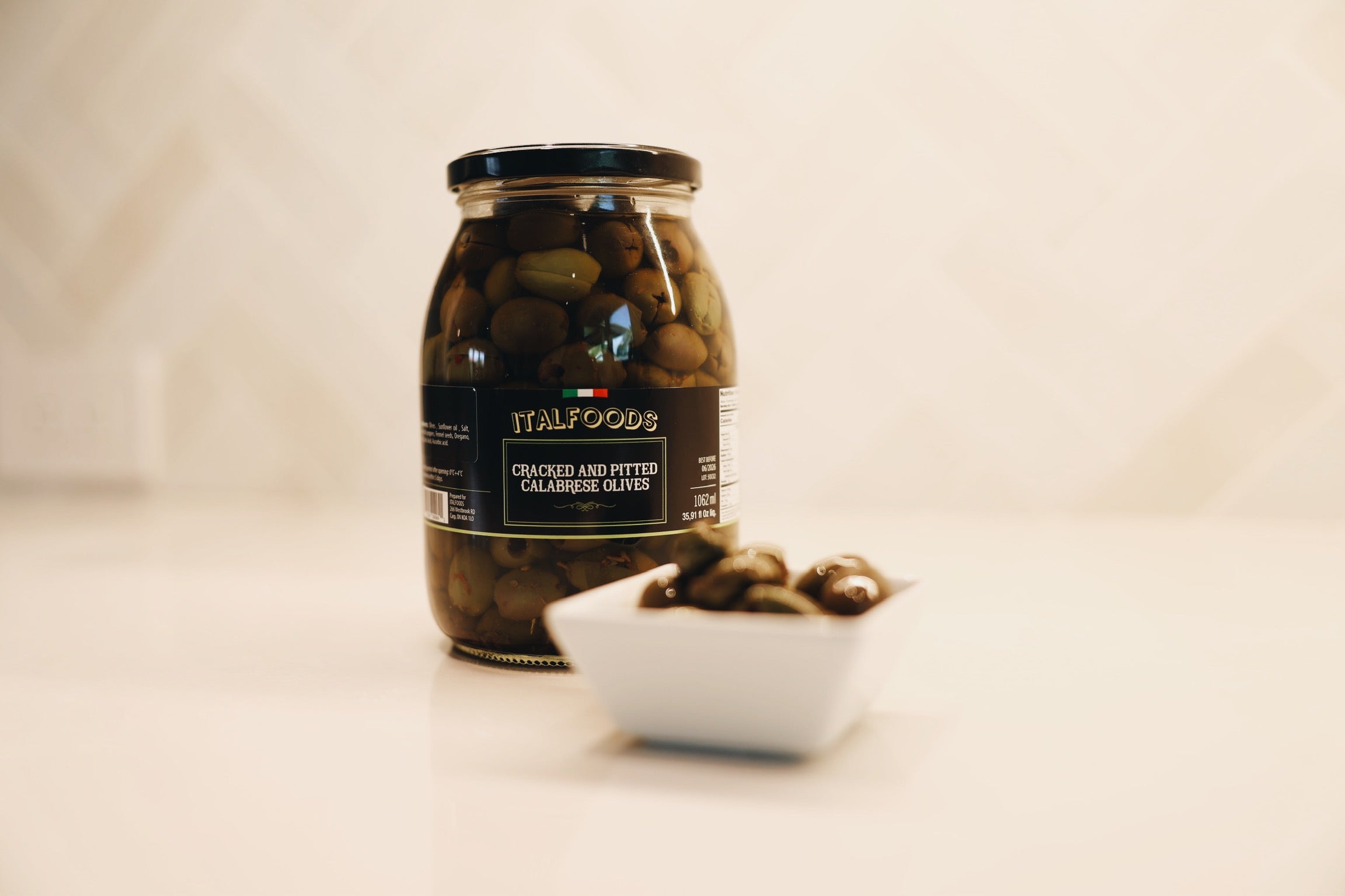 Jar of olives with a label on a light background