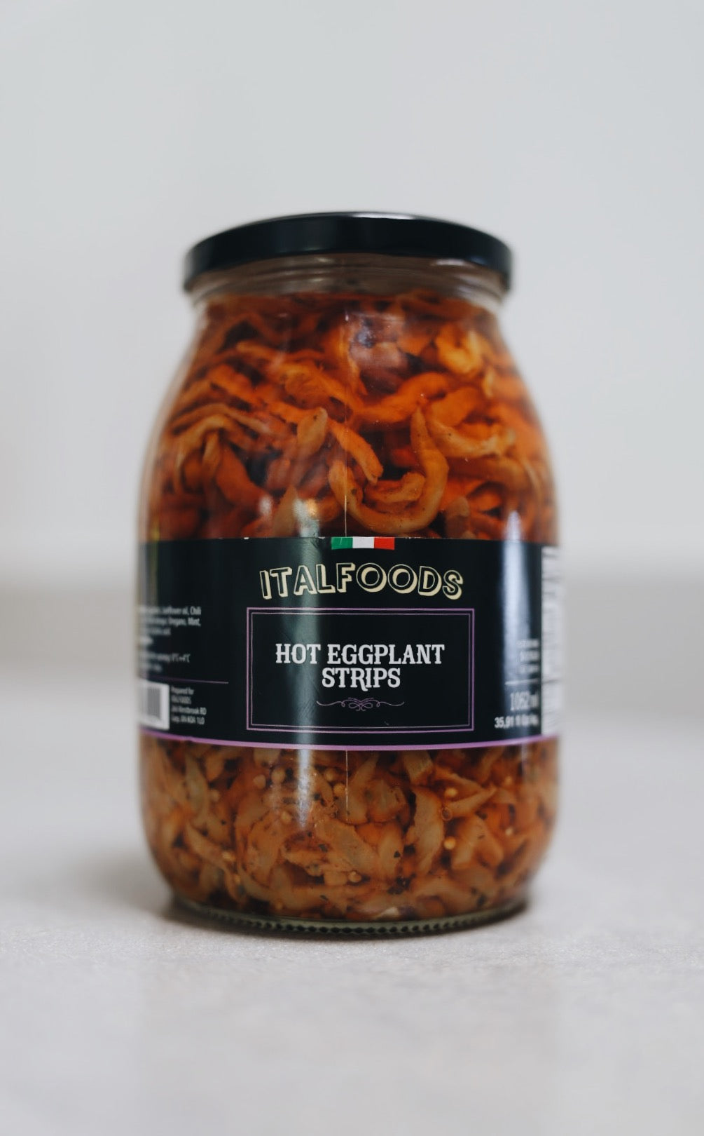 Jar of ITALFOODS Hot Eggplant Strips on a white background
